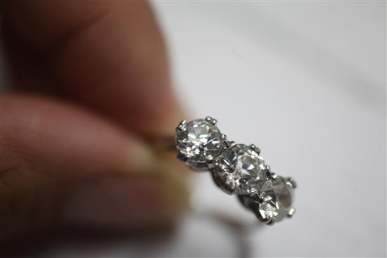 A mid 20th century platinum and three stone diamond ring, size L.